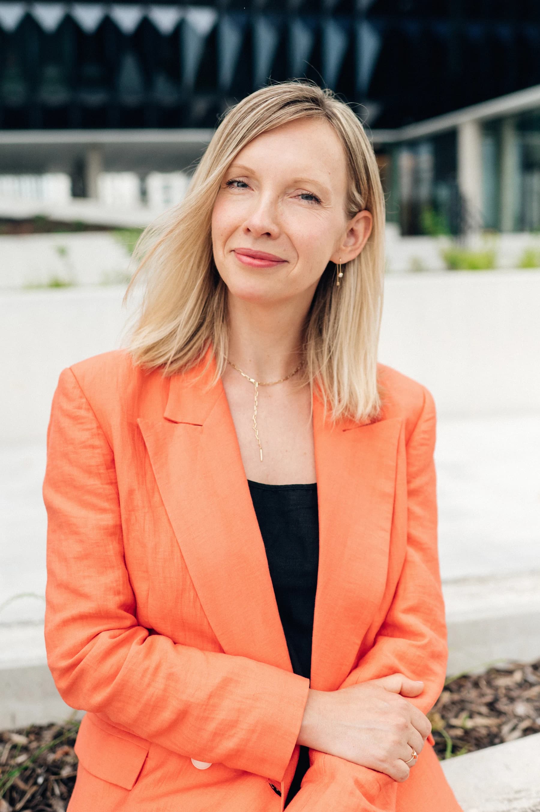 Dana Rollinger outdoors in an orange blazer